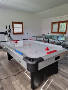 una mesa de ping pong en una habitación con 2 mesas en Domki u Jacka - sauna bilard tenis air hockey piłkarzyki bawialnia plac zabaw, en Czerwienne