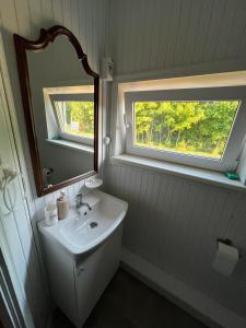 łazienka z umywalką, lustrem i oknem w obiekcie Vasaras Sapnis w mieście Nida