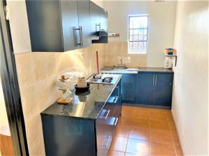 een keuken met blauwe kasten en een zwart aanrecht bij Cousy studio with kitchenette in Norton - 2120 in Norton