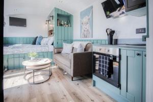 uma pequena sala de estar com um sofá e uma cama em Willows Rest - 1 Bed Shepherds Hut - Pentlepoir em Saundersfoot