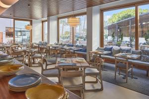 a restaurant with tables and chairs and windows at Hotel Tres Torres in Santa Eularia des Riu
