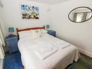 a bedroom with a white bed with two towels on it at The Hen House in Bridgend