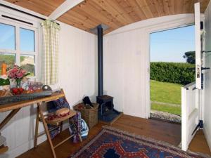 a room with a fireplace and a large window at Shepherd's Hut in Bridgend
