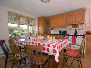 a kitchen with a table with a red and white table cloth at Slade Cottage in Bridgend