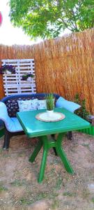 a green table and a bench with a potted plant on it at Paradise Camp Sozopol in Sozopol