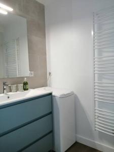 Un baño blanco con lavabo y espejo. en appartement Plein Sud, en Auray 9 fotos más