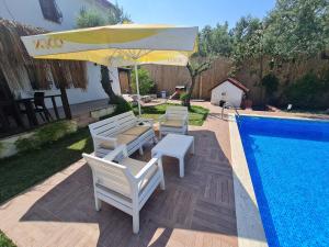 a patio with chairs and an umbrella next to a swimming pool at Antik House İznik in İznik