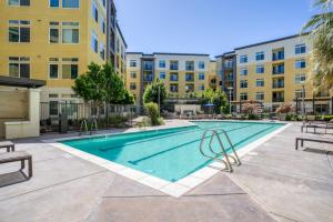 una piscina con mesas y sillas frente a los edificios en Dublin 2BR w Gym Lounge Pool nr BART SFO-977, en Dublin