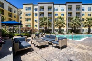 Un patio con tumbonas y una piscina. en Dublin 2BR w Gym Lounge Pool nr BART SFO-977, en Dublin