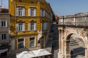 a yellow building with an arch and an archway at Apartman Nika in Pula