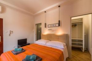 a bedroom with a large bed with an orange blanket at Apartman Nika in Pula