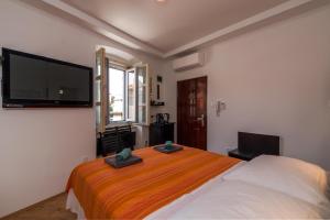 a bedroom with a bed and a flat screen tv at Apartman Nika in Pula