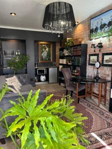 a living room with a table and some plants at Royal Library Room in Mossel Bay