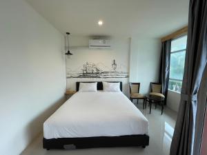 Rúm í herbergi á Dwell Phuket Airport Hotel at Naiyang