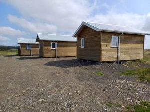 eine Reihe von Holzgebäuden auf einem Feld in der Unterkunft Gaukshof in Selfoss