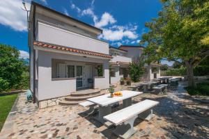 un patio con mesa y bancos frente a un edificio en Apartments Grota en Poreč