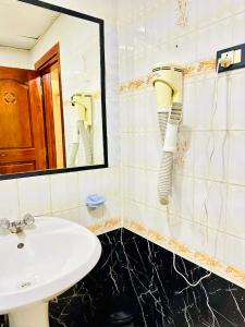 a bathroom with a sink and a blow dryer on the wall at Royal Village Hotel in Dar es Salaam