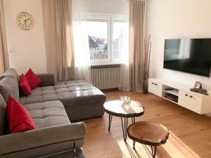 uma sala de estar com um sofá e uma televisão de ecrã plano em Ferien am Weinberg em Kappelrodeck