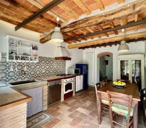 a kitchen with a table and a dining room at Intero alloggio campagna Lucca in Capannori
