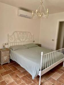 1 dormitorio con cama blanca y lámpara de araña en Intero alloggio campagna Lucca en Capannori