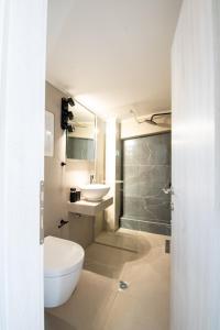 a bathroom with a toilet and a sink and a shower at Ennea suites-Space suite in Flámbouras