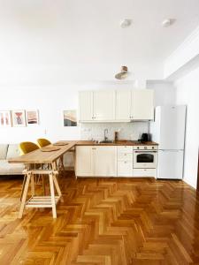 a kitchen with white cabinets and a wooden floor at Plaka athens 1 bedroom 4 persons apartment by MPS in Athens