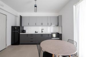 a kitchen with a table and a refrigerator at Ennea suites-Space suite in Flámbouras