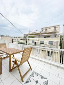 eine Terrasse mit einem Holztisch und Stühlen auf dem Balkon in der Unterkunft Plaka athens 1 bedroom 4 persons apartment by MPS in Athen