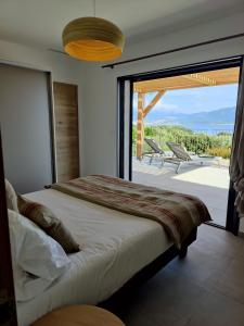 a bedroom with a bed and a large glass window at Résidence La Plage in Propriano