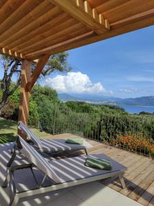 una terraza con 2 tumbonas y una pérgola en Résidence La Plage, en Propriano