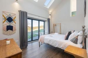 a bedroom with a bed and a large window at Green End Farm Cottages The Stables in Goathland