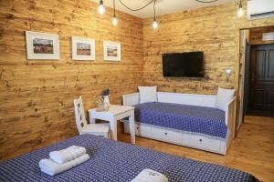 een slaapkamer met 2 bedden en een flatscreen-tv bij Pension Angusfarm in Soběsuky