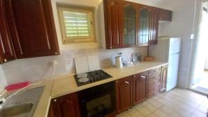 a kitchen with wooden cabinets and a stove and a sink at ALMA in Makarska