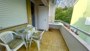 a balcony with a table and chairs on a porch at ALMA in Makarska