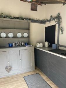 a kitchen with white cabinets and a counter top at Willow glamping in Norwich