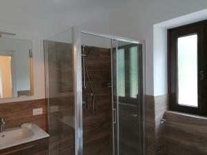 ein Bad mit einer Glasdusche und einem Waschbecken in der Unterkunft Sweet Home Casa Vacanze il b&b in Songavazzo