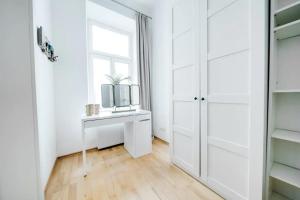 a white dressing room with a mirror and a window at Margarete Family Stay in Vienna