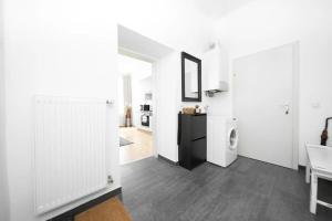 a living room with white walls and a hallway with a washing machine at Margarete Family Stay in Vienna