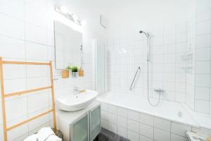 y baño blanco con lavabo y bañera. en Margarete Family Stay, en Viena