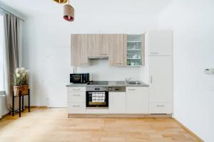 cocina con armarios blancos y fogones en Margarete Family Stay, en Viena