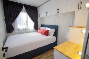 ein kleines Schlafzimmer mit einem Bett und einem Fenster in der Unterkunft ELIES TINY GLAMPING in Ayvalık