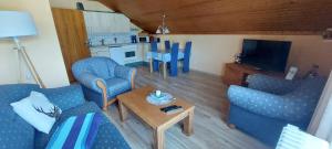 a living room with two blue chairs and a table at Landhaus Kathrin in Walkenried