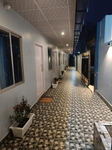 a hallway with a tile floor with potted plants at The Corner Inn (Lodge) in Guwahati
