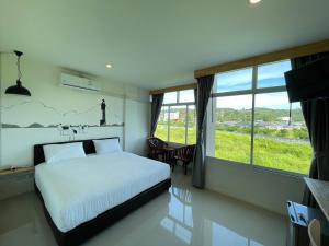 Rúm í herbergi á Dwell Phuket Airport Hotel at Naiyang