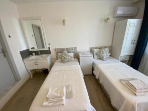 セルチュクにあるVilla Panoramaのベッド2台、洗面台、鏡が備わる客室です。
