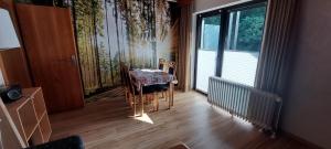ein Esszimmer mit einem Tisch und einem Fenster in der Unterkunft Landhaus Kathrin in Walkenried