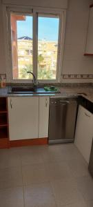 a kitchen with a sink and a window at Aguamarina, las Calitas, frente al mar in Orihuela