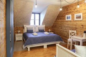 a bedroom with a bed and a wooden wall at Pension Angusfarm in Soběsuky