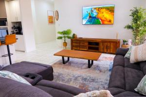 a living room with a couch and a coffee table at Top End Getaway - Luxury Home in Palmerston
