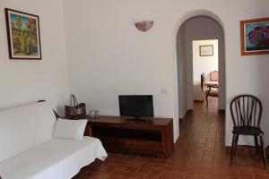 a bedroom with a bed and a desk with a tv at Agriturismo la Lecciola in Rio nellʼElba